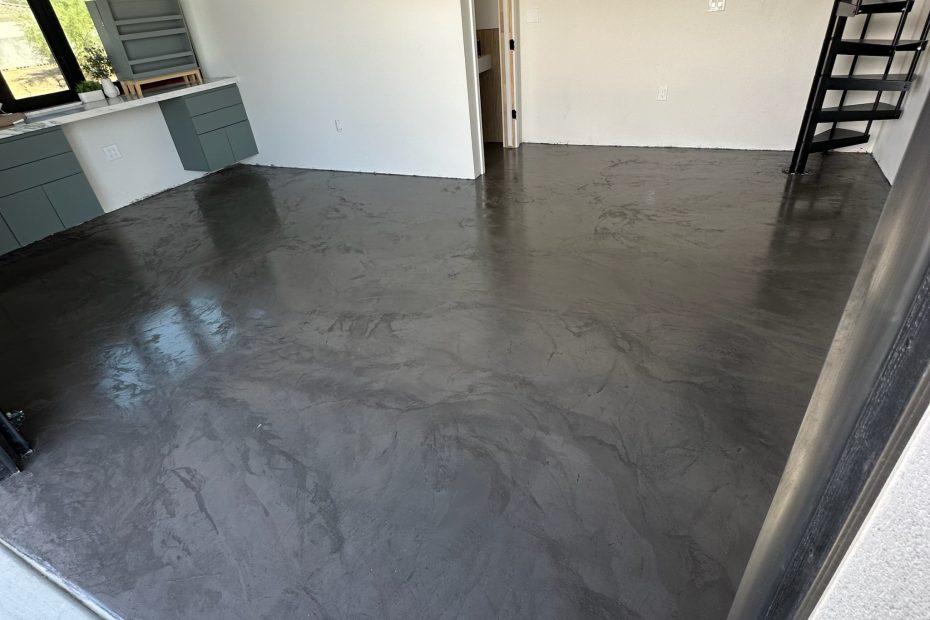 Dark polished floor in a bright room with a black spiral staircase